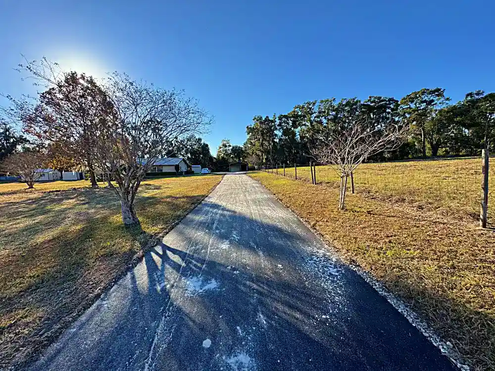 Rural property driveway with fenced pastures