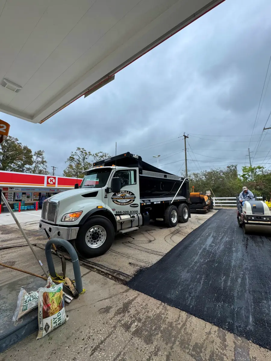Asphalt paving work beside an Asphalt Paving and Maintenance dump truck