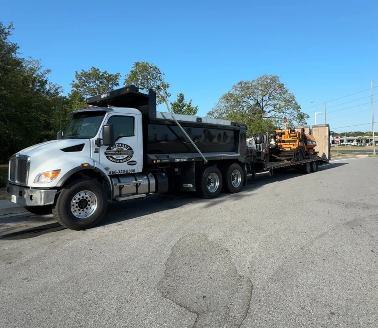 Asphalt maintenance truck transporting paving equipment