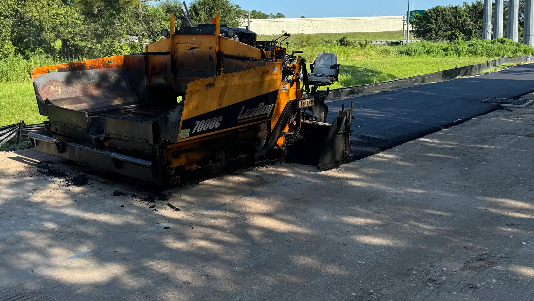 Asphalt paving equipment placing pavement on a roadway