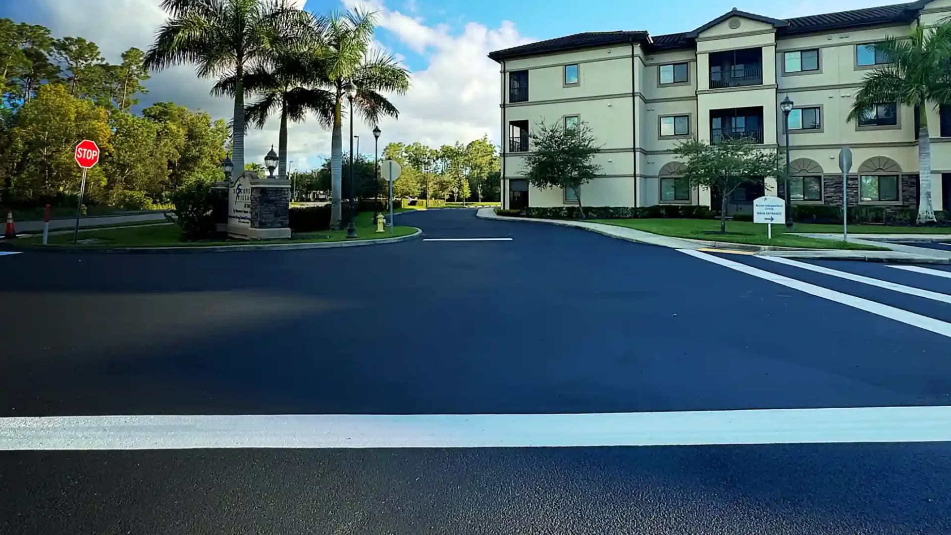 Dark sealcoated commercial roadway with crisp white traffic markings