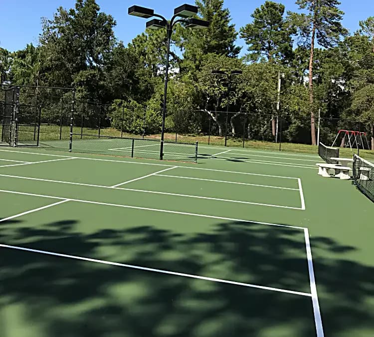 Resurfaced outdoor tennis courts with fresh white lines