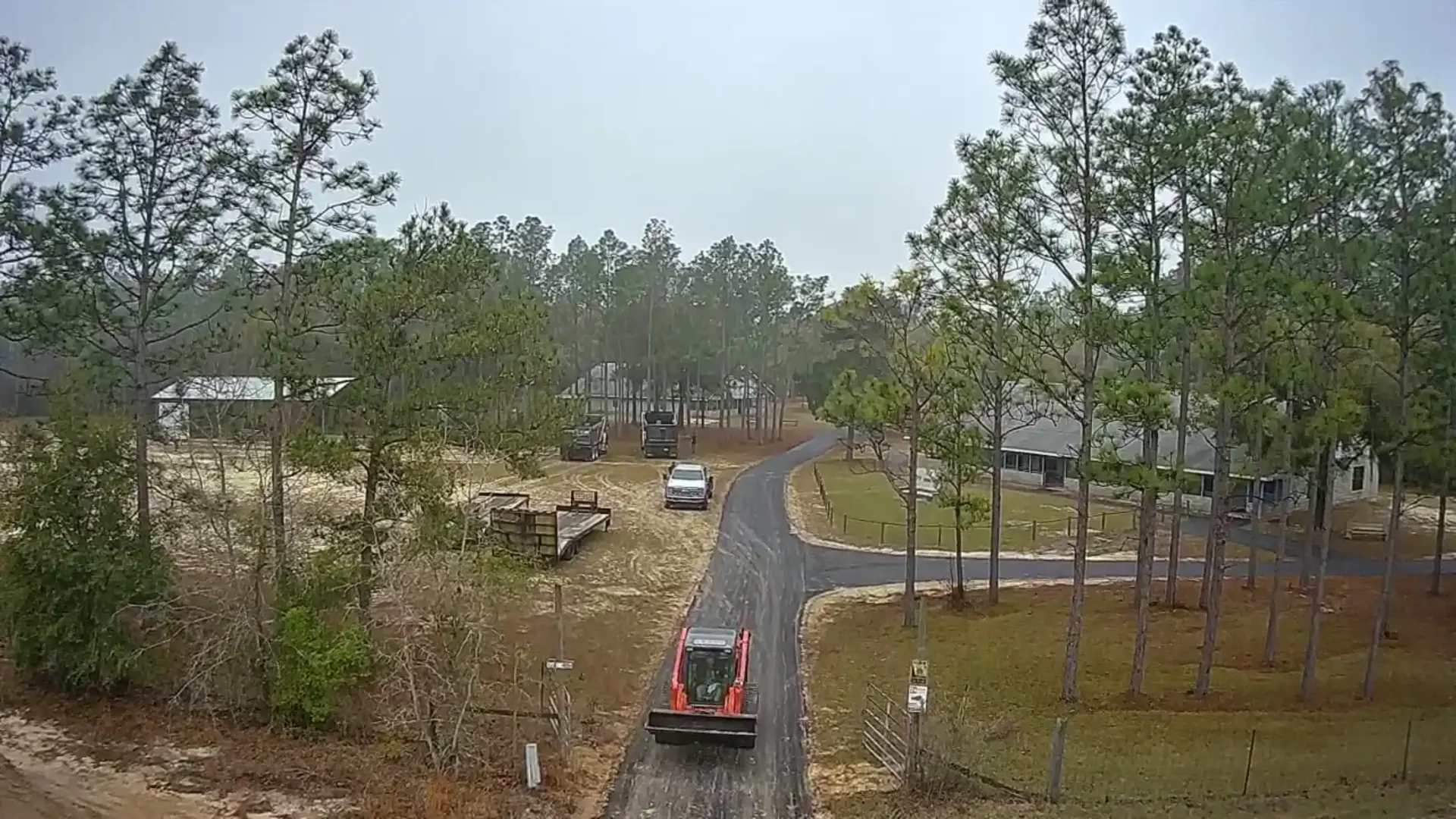 Aerial view of a newly paved private driveway with paving equipment on site