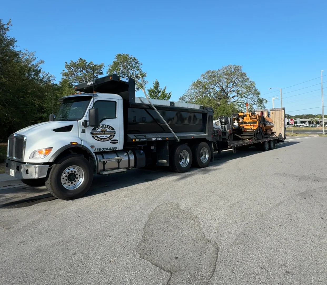 Asphalt maintenance truck transporting paving equipment